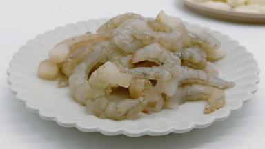 脊岭岛盐田虾从盒子取出，先不剪开包装袋，直接把虾在流水下冲洗几次化冻，这样不影响虾仁的口感。化冻的虾仁加适量的盐与料酒，抓上几下腌制5分钟。