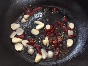 重新热油锅，放入蒜片、干辣椒爆香