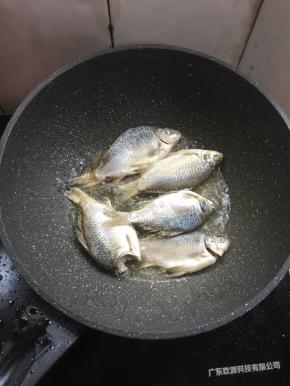 锅烧热倒入适量的油，放入腌制好的鲫鱼中小火慢慢的煎。