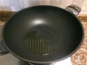 热锅倒油烧至八成热。