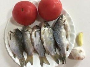 准备好所需食材：
小鲫鱼刮去鱼鳞，去内脏和鱼鳃，用盐腌制15分钟备用，西红柿两个，蒜瓣一个，生姜一块。