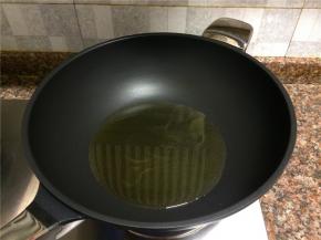 热锅倒油烧至七成热。