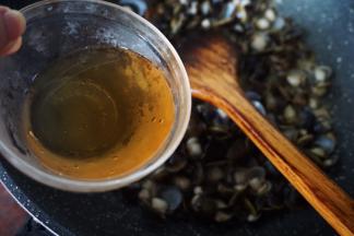 蛤开口后淋入梅汁翻炒