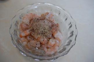 虾线去除好后过一下清水后用厨房纸巾拭干后放入碗里，加入料酒、黑椒碎和盐拌匀后放入冰箱冷藏10分钟