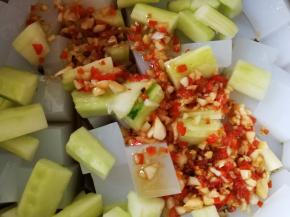 把黄瓜倒入凉粉放入容器里面，把锅里的酱汁倒入容器里，翻拌均匀