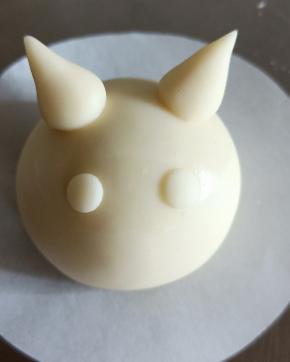 抹少许牛奶粘在面团中央两侧，轻轻压扁