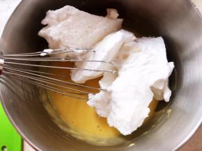 取一部分打发好的蛋白加入到蛋黄糊中，先用蛋抽翻拌均匀