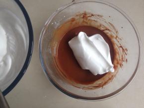 用刮刀将三分之一打发好的蛋白霜勺到蛋黄糊里，从底部向下翻拌并切拌均匀