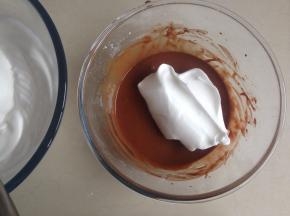 用刮刀将三分之一打发好的蛋白霜勺到蛋黄糊里，从底部向下翻拌并切拌均匀