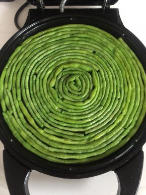 电饼铛放入少许油，把焯好水的豇豆盘在电饼铛里。