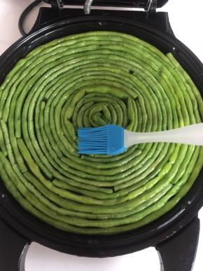 插上电源，用硅胶刷在豇豆表面均匀的刷一层油。