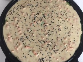 在面糊表面撒上适量的黑芝麻。