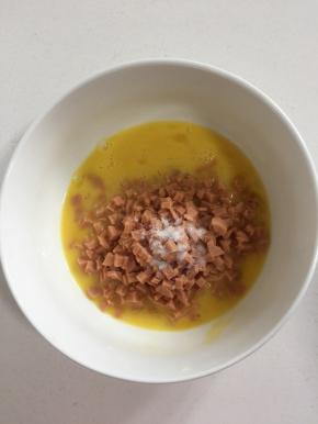 放入切好的火腿丁和一勺盐搅拌均匀。