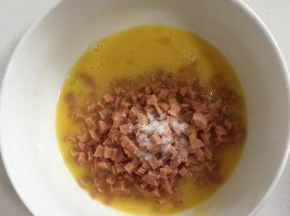 放入切好的火腿丁和一勺盐搅拌均匀。