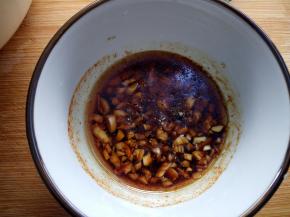 碗中放入切好的蒜末。加入20克李锦记天成一味特级鲜。20克麻油，适量胡椒粉，辣椒粉，十三香，香醋，盐和白糖搅拌均匀。