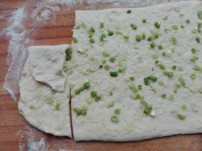 按照图片所示，从一端用刀将两头分别切开一下，注意，切开的部分正好是整个面片宽度的三分之一即可，然后将其朝中间对折。