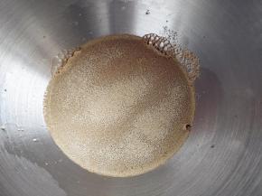 把胡萝卜汁倒入厨师机或面包机桶内（也可以手动和面），倒入酵母粉。