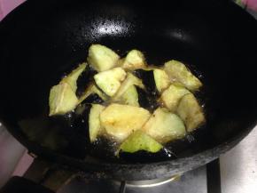 炒锅加油烧热，大火，分次下入茄块炸成金黄色捞出控油