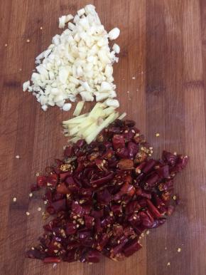 蒜瓣剥皮剁碎，生姜切成条，干辣椒清洗一下再切成段儿备用。（干辣椒用水清洗一下，下锅不容易糊哦！一般人我不会告诉她这个小技巧哦！）