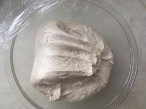 之后将面团折叠至对面，这一面折叠好后，转一下容器，将四面都用同样的方法折叠一下，之后盖保鲜膜继续发酵