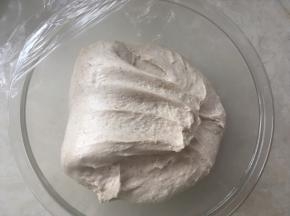 之后将面团折叠至对面，这一面折叠好后，转一下容器，将四面都用同样的方法折叠一下，之后盖保鲜膜继续发酵