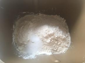 面包机内加入高筋面粉，全麦面粉跟盐