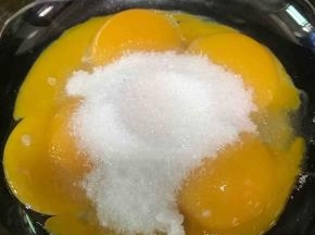 蛋黄加入40克细砂糖，用手动打蛋器搅拌均匀至细砂糖融化无颗粒。