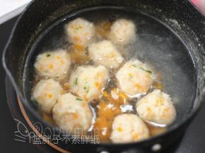 烧开一锅热水后大火转中小火，用手挤出丸子，用勺子刮入锅中。