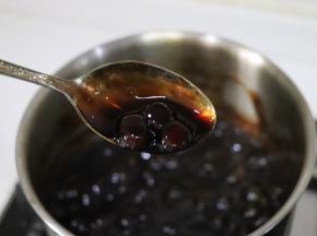 搅动珍珠，防止粘底，糖水会变得浓稠，珍珠也变黑，通透，就成为黑珍珠糖浆了。