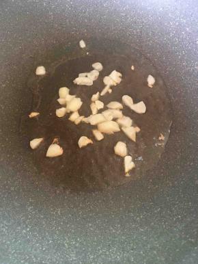 锅中热油后放入蒜片煸香。