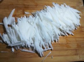 2 把萝卜切成片，再切成丝。尽量的切细一点，比较容易入味。