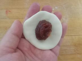 依次包入豆沙馅，收口捏紧