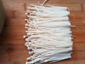 4、金针菇切去根部，用流动水冲洗一下。