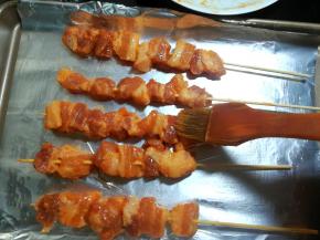 7 烤盘里铺上锡纸，用刷子刷上一层薄油。放上肉串，在肉串上也刷上一层薄油。这样在烤的时候肉不会太干。