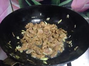 放入腌制好的肉片，翻炒至变色断生