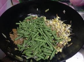 加入豆角和黄豆芽翻炒，加入食盐、生抽、蚝油翻炒入味