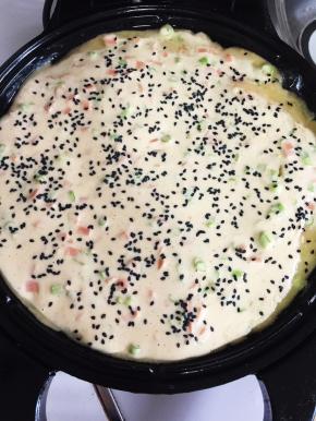 在面糊表面均匀的撒上适量的黑芝麻。