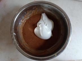 舀一勺蛋白霜与可可面糊翻拌。