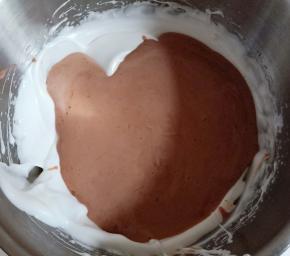 将拌匀的可可面糊倒回剩余蛋白霜中翻拌、切拌均匀。