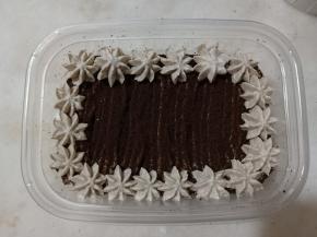 表面挤上一圈花纹，装饰上饼干和巧克力脆珠即可。