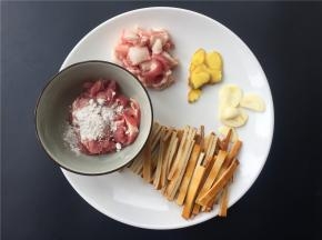 将肥肉和瘦肉分开分别切丝，瘦肉加入适量淀粉拌匀；大蒜生姜切片；豆腐干切条。