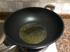 热锅倒油烧至七成热。