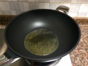 热锅倒油烧至七成热。