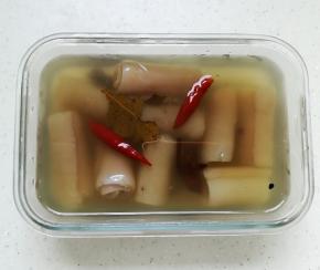 汁水晾凉后倒入容器中，再把肉皮卷放入里面腌制六小时