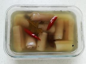 汁水晾凉后倒入容器中，再把肉皮卷放入里面腌制六小时
