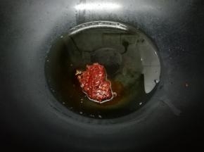 炒锅里加入适量油，把辣味豆瓣酱放入锅中煸出红油