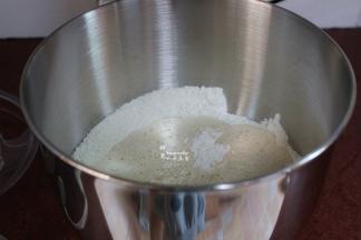 接着把白砂糖、盐、啤酒、牛奶、鸡蛋倒入厨师机内，装上和面棒，启动电源，用低档慢慢的搅拌，面粉和水混合成面团，改为4档，开始揉面。