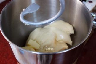 持续揉至面团变的光滑，这个时候加入软化的黄油，继续揉面。刚加入黄油的时候，粘再壁上到处都是，可以不用管，继续4档揉面。