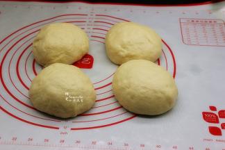 将发酵好的面团，用手排出空气，再成4个小面团，揉成光滑，用保鲜膜包裹，松弛10分钟。