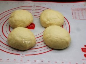 将发酵好的面团，用手排出空气，再成4个小面团，揉成光滑，用保鲜膜包裹，松弛10分钟。